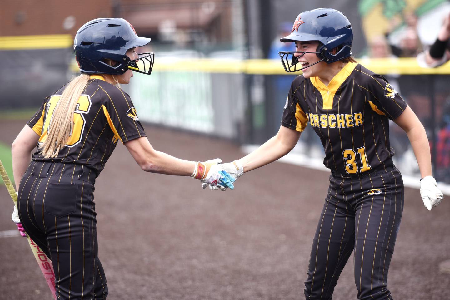 Herscher's RyLyn Adams, right, is congraulated by teammate Addy Whitaker after scoring a run in the Tigers' Class 2A Seneca Sectional semifinal against Beecher Tuesday, May 27, 2025.
