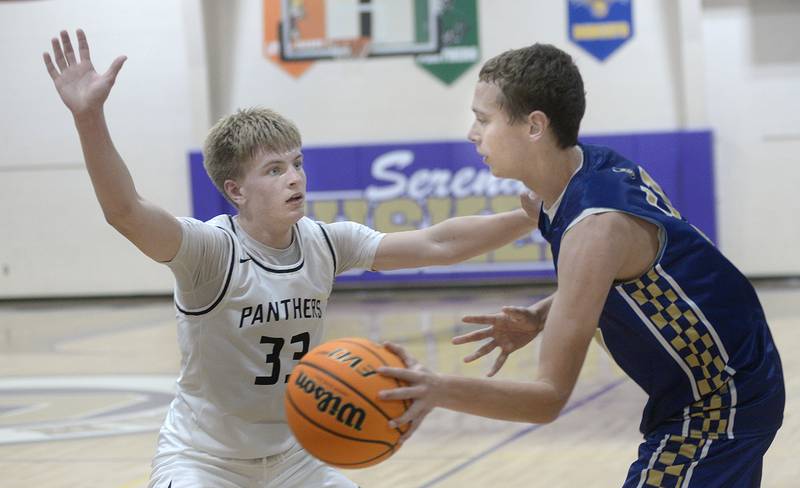 Erie/Prophetstown’s Sawyer Copeland works to block the pass attempt by Marquette’s Lucas Craig in the 4th period Monday at the Serena Huskers Hardwood Tip-Off Tournament.