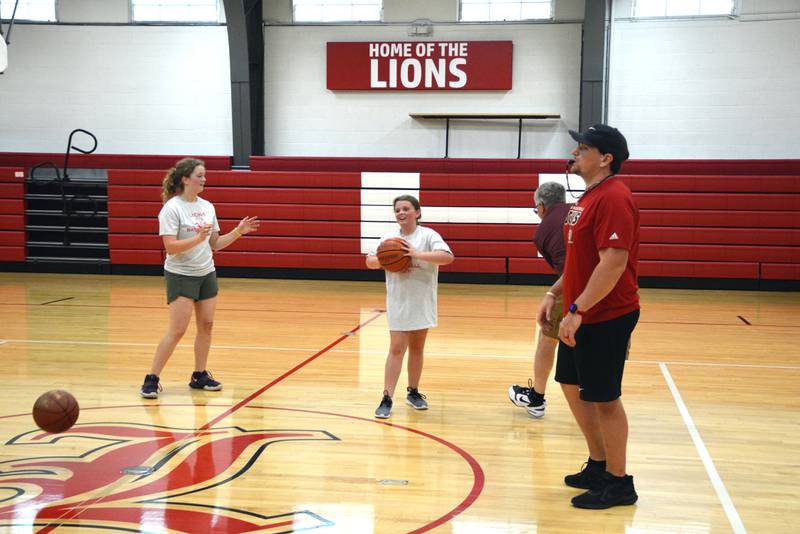 Chance Blumhorst, new varsity boys basketball coach, keeps an eye on the drills during Thursday session of the basketball camp at LaMoille High School.