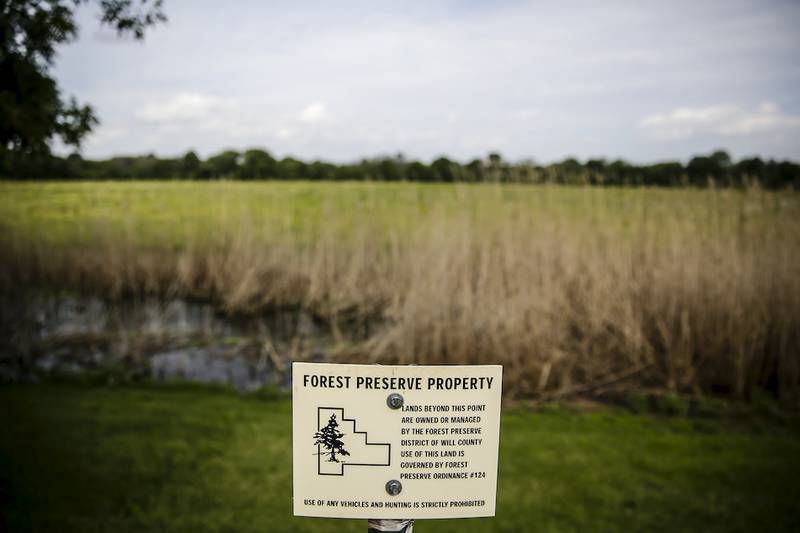 A Forest Preserve District of Will County sign sits at the edge of a residential property in the River Glen subdivision in Joliet. Homeowners with land abutting forest preserve land have become upset over the district's recent decision to increase its encroachment enforcement efforts.