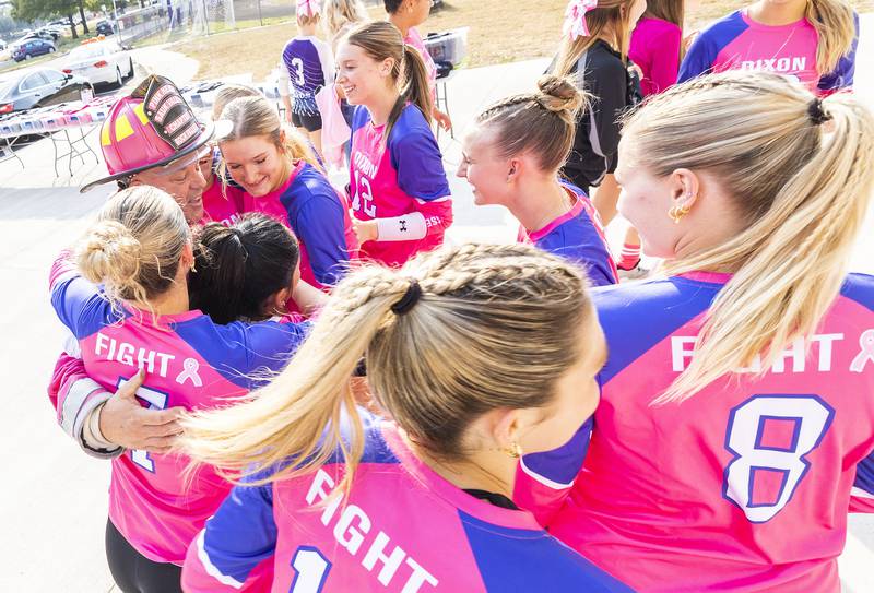 Pink Heals Sauk Valley president Brian Tribley is mobbed by members of the Dixon High School varsity volleyball team Thursday, Oct. 2, 2025. In recognition of Breast Cancer Awareness Month, the teams raised money through donations and sales to donate $500 to Pink Heals and also a donation to a community member battling cancer.