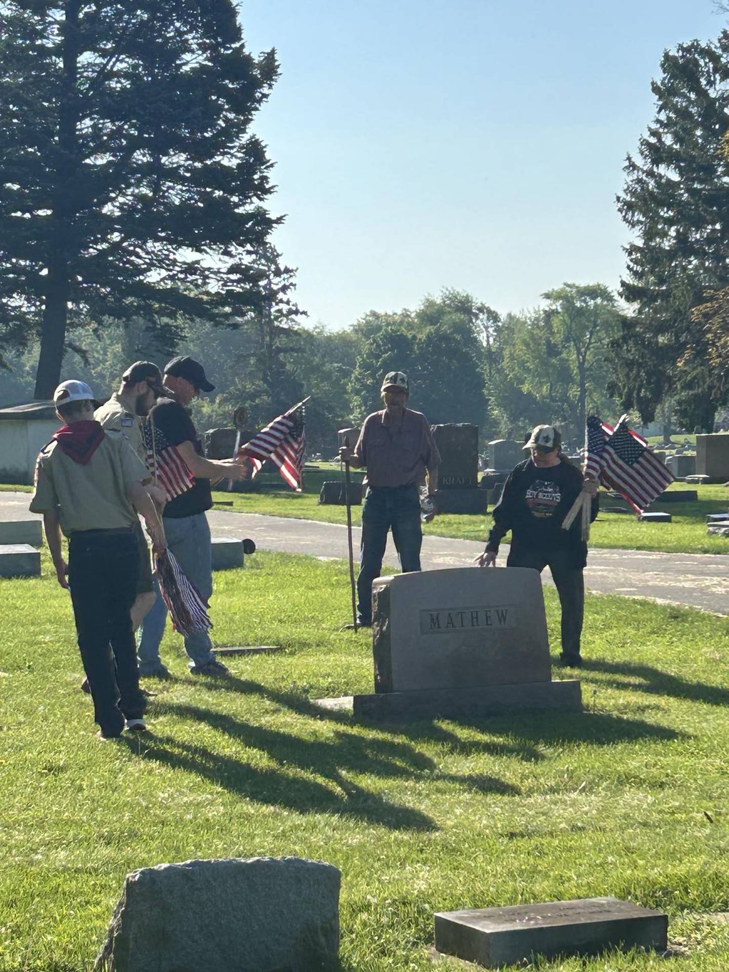 A group of volunteers gathers around a veteran's gravesite Saturday, May 18, in Grove Hill Cemetery, Morrison.