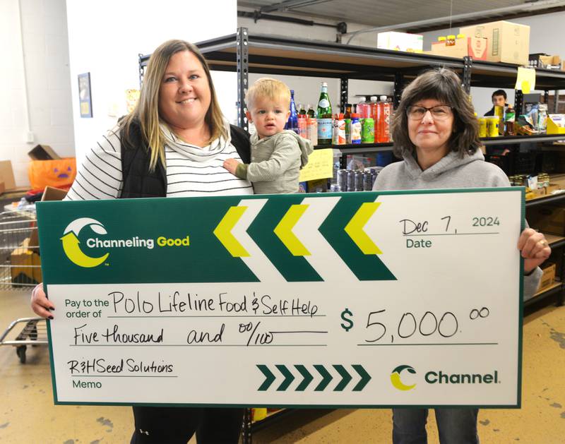 Ellen Rahn of Channel Seed (left) and her son Evan, present a $5,000 mock check to Kathy Wragg of the Polo Lifeline & Self Help food pantry on Saturday, Dec. 7, 2024. Wragg said the donation will be used to purchase beef for the pantry.