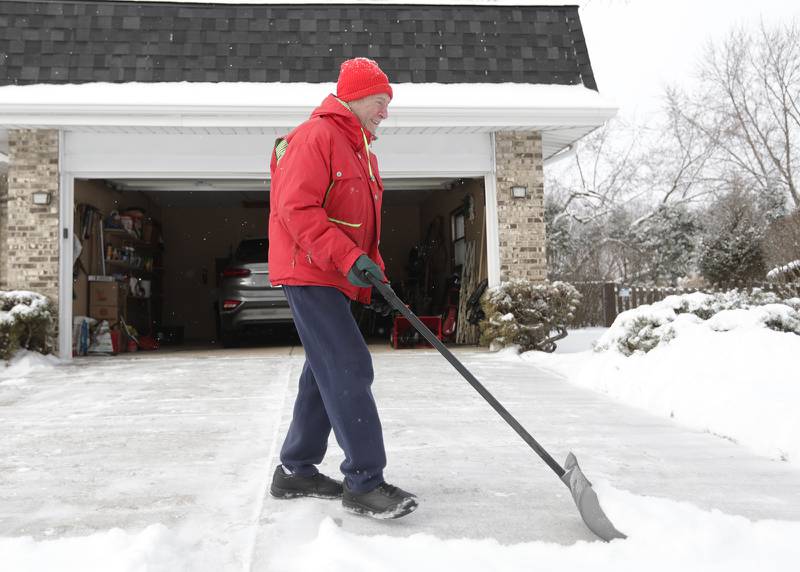 Steve Dudas shovels snow from his driveway in Downers Grove on Monday, Jan. 24, 2022.