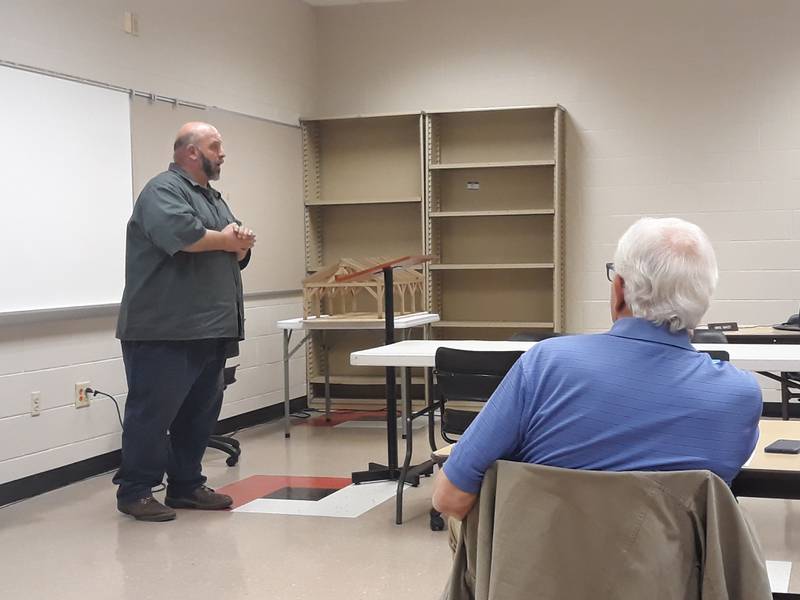 In the second time in as many weeks, Streator High School vocational teacher David Taylor makes a presentation about the picnic pavilion his woodworking class will build for the city of Streator at Marilla Park. A scaled model is behind him. Board member Gary Wargo looks on as Taylor explains the project to the board Tuesday, April 19, 2022.