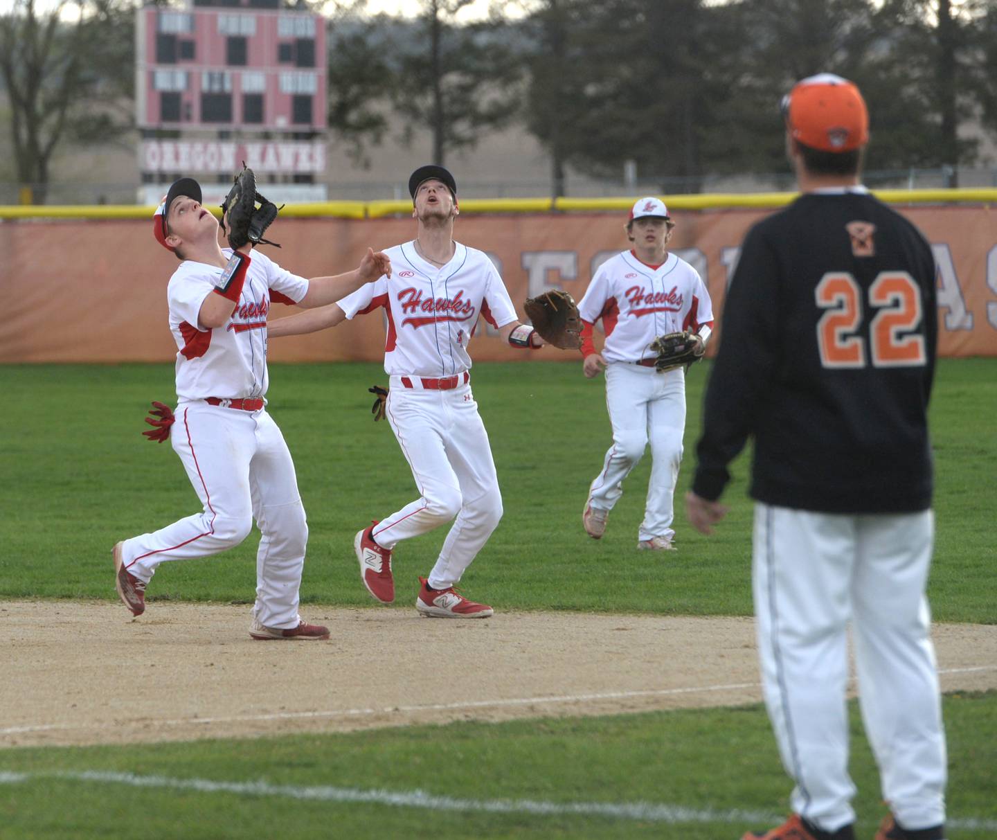 Oregon first baseman Dom Terkikowski, left, and second baseman Hunter Buchanan, center, move under a pop fly during an April 20 game with Winnebago.