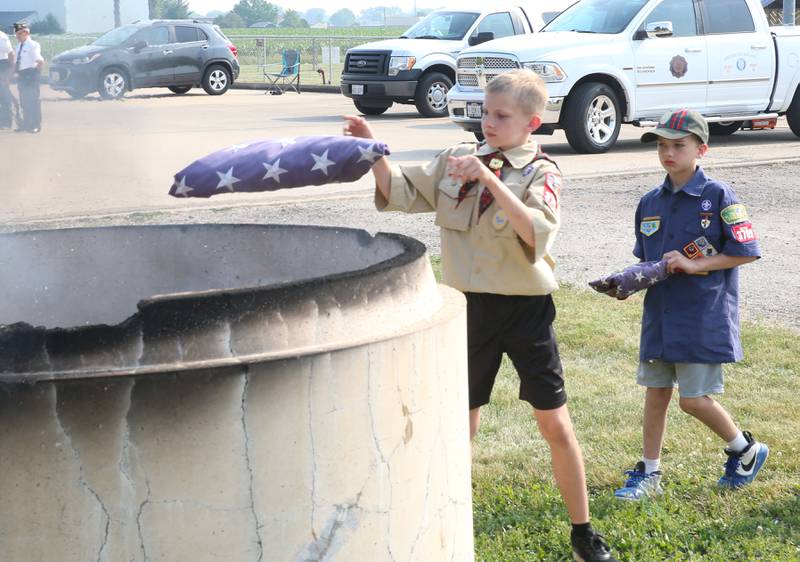 Micah Washkowiak of Peru Boy Scout Troop #123 and Evan Hall of Cub Scout Troop #3709 retire American Flags into a burning cauldron during the Flag Retirement Ceremony on Wednesday, June 14, 2023 at Veterans Park in Peru. Each year on Flag Day, the group retires flags while holding a ceremony with Boy Scout Troop 123 and Cub Scout 3709 from Peru.