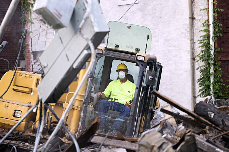 Patrick Burke picks through electrical boxes and other recyclables Tuesday, Sept. 5, 2023 while taking down the building.