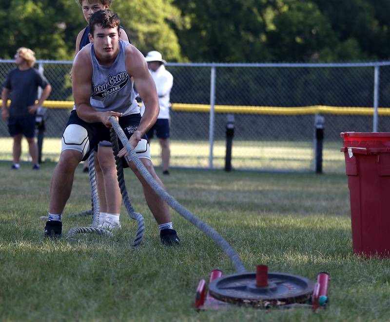 Cary-Grove’s Logan Abrams pulls a weighted sled while doing conditioning drills during summer football practice Thursday, June 30, 2022, at Cary-Grove High School in Cary.