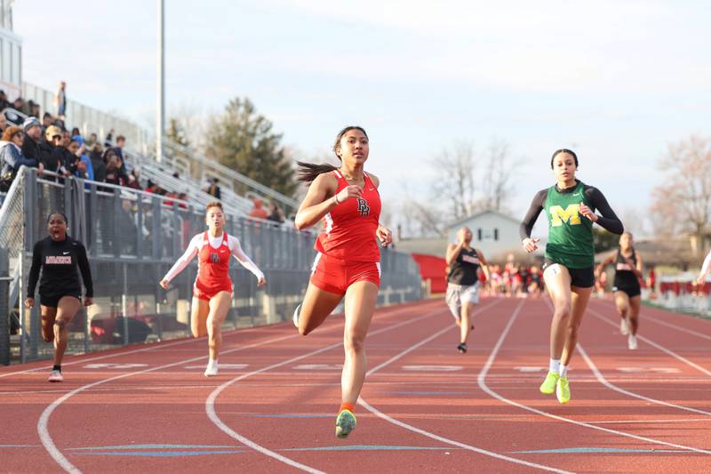 Bradley-Bourbonnais' Niyah Crockett, center, finishes ahead of Bishop McNamara's Jersey Slone in their heat of the 100-meter dash during the Boilermaker Invite on Thursday, April 3, 2025. Crockett would claim second overall and Slone would claim fourth overall.