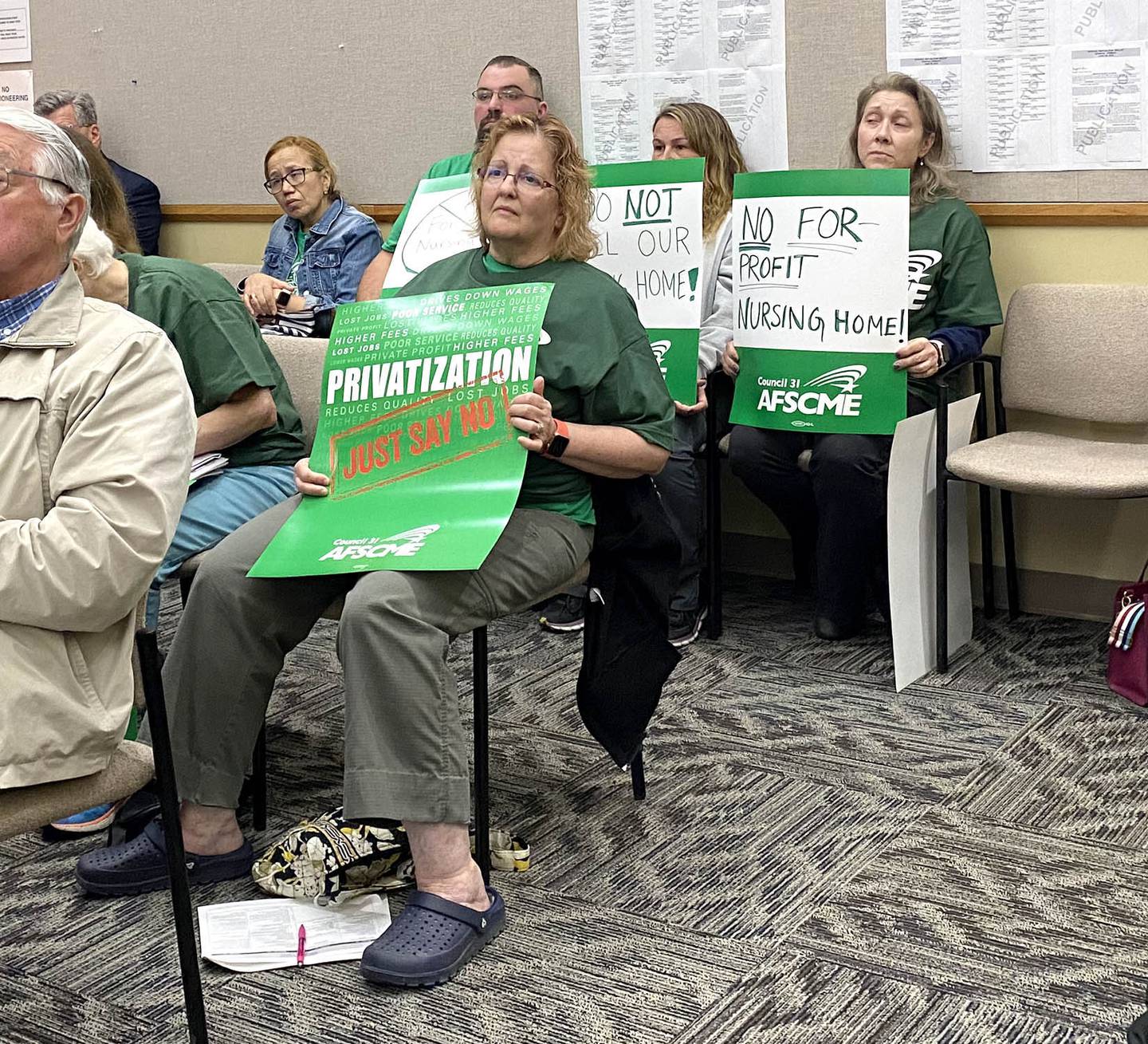 Members of the American Federation of State, County and Municipal Employees #3537, the AFSCME union which represents DeKalb County nursing home employees, hold signs during the DeKalb County Board's Committee of the Whole meeting Wednesday, June 8, 2022, to ask the board not to sell the DeKalb County Rehabilitation and Nursing Center. Union members said a privatization could mean lost benefits for employees, and lowered standards of patient care under new management.