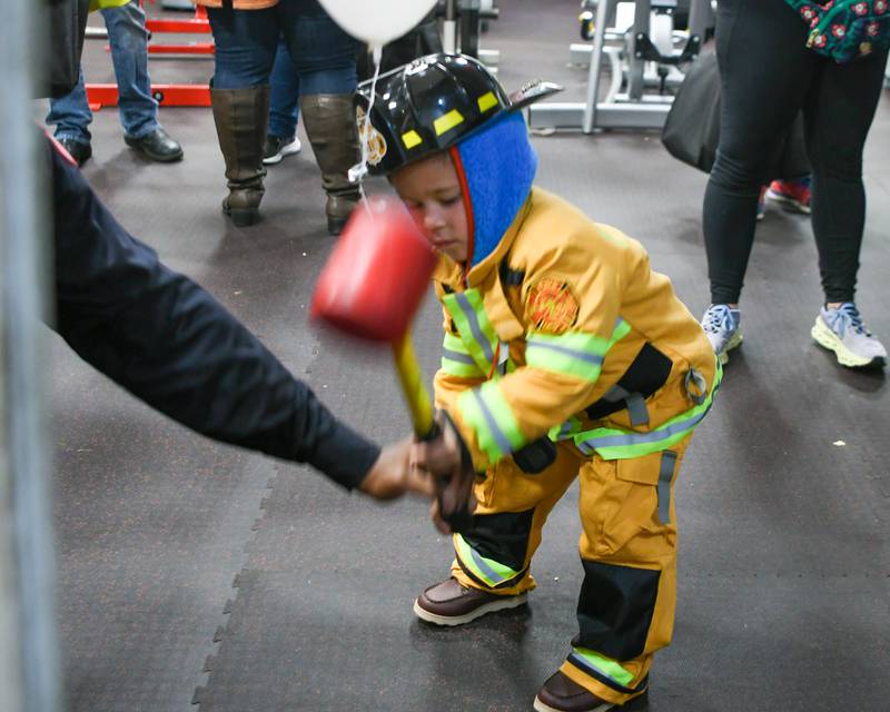Oliver de la Peña, 5 year old, of Westmont tries out his strength on a game during the 100 year anniversary celebration of the Westmont fire department fire house on Saturday Oct. 14, 2023.