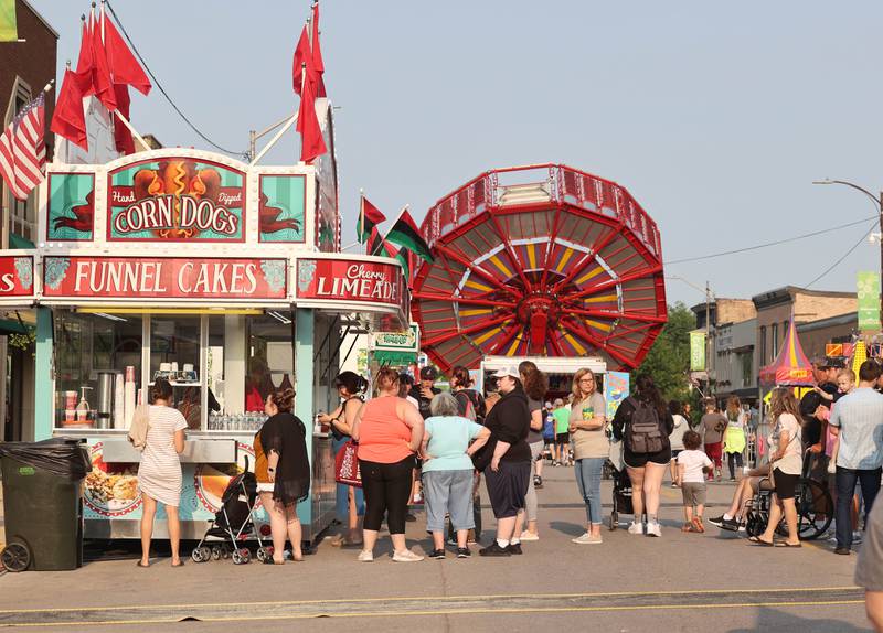 Visitors wait for food as others enjoy the rides during Genoa Days, Wednesday, June 7, 2023, in downtown Genoa.