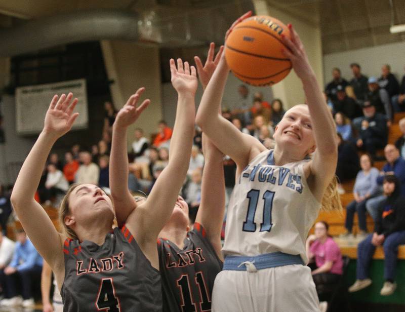Cissna Park's Sophia Duls grabs a rebound over Flanagan-Cornell/Woodland's Aubry Edens during the Class 1A Sectional semifinal game on Tuesday, Feb. 25, 2025 at Midland HIgh School.