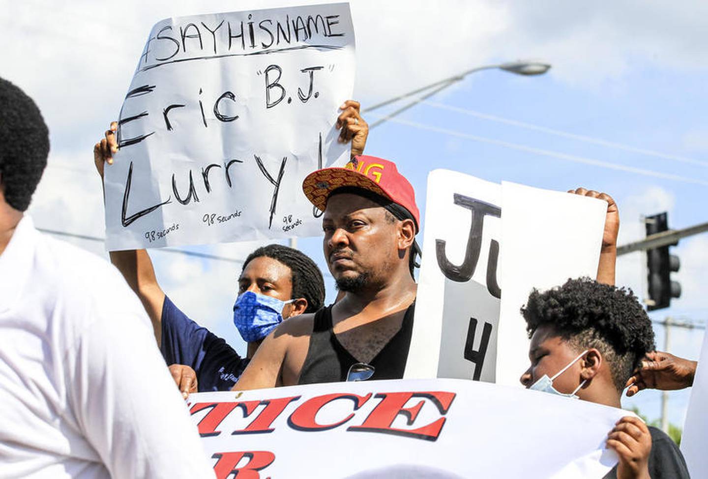 Protestors can be seen demonstrating against police brutality and justice for Eric Lurry on Sunday, Jul. 26, 2020, at the corner of Larkin Avenue and Jefferson Street in Joliet, Ill.