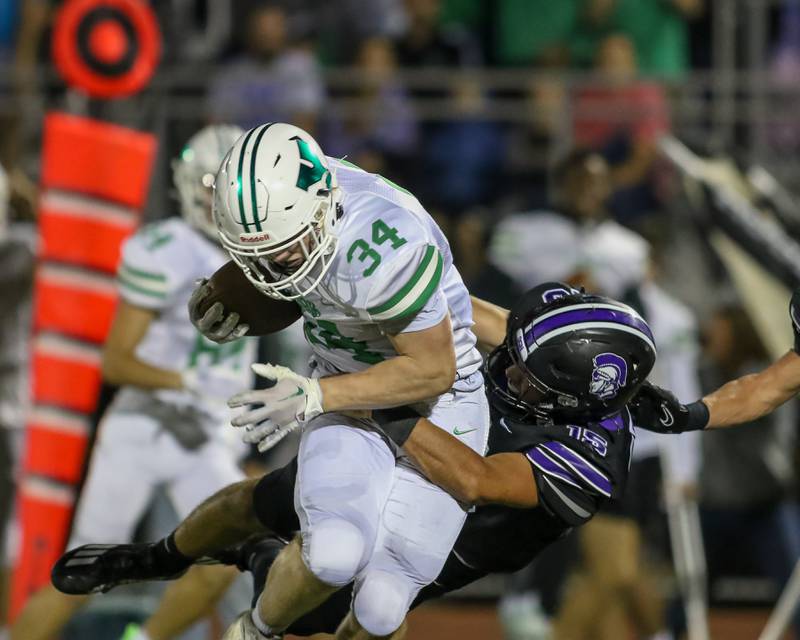 Downers Grove North's Weston Waughop (15) makes a tackle on York's Jimmy Connors during football game between York at Downers Grove North.  Sept 29,
