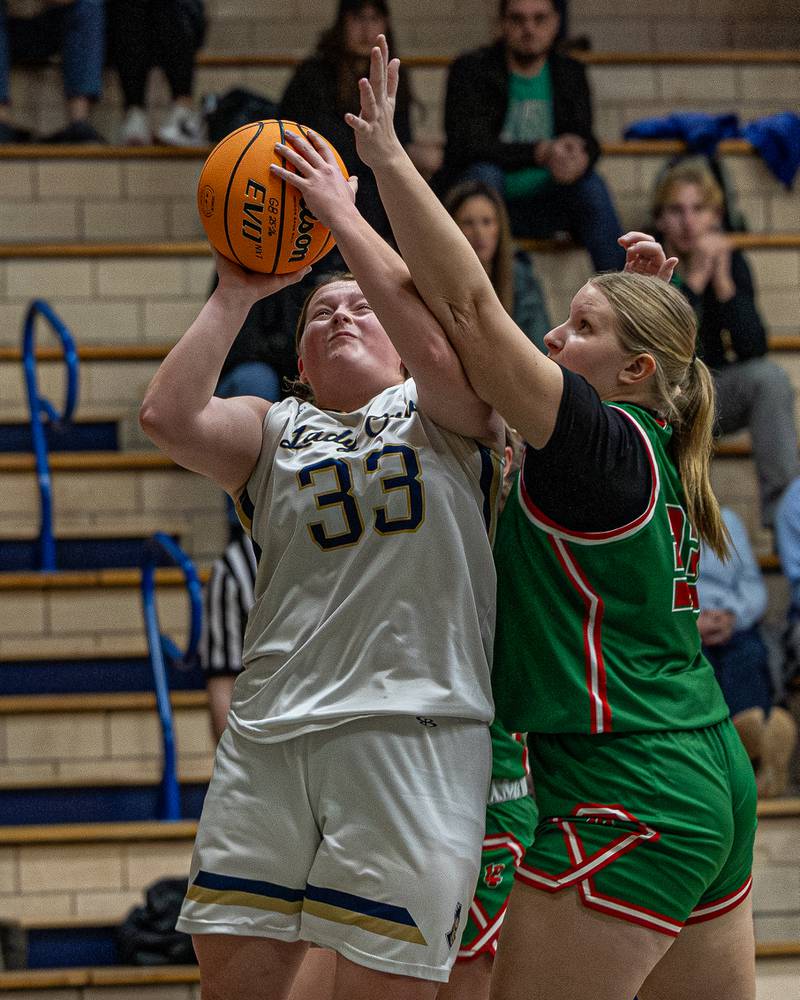 Madison Kozlowski (33) of Marquette lays ball up whilst Lily Morscheiser (33) of LaSalle-Peru attempts to deflect shot on Saturday, January 3, 2026 at Marquette Academy in Ottawa.