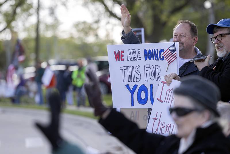 A supporter leans out of a car Friday, May 1, 2026, during a May Day protest at Central Park in Sterling. Indivisible Sauk Valley organized the gathering to continue to voice their displeasure with the Trump Administration.