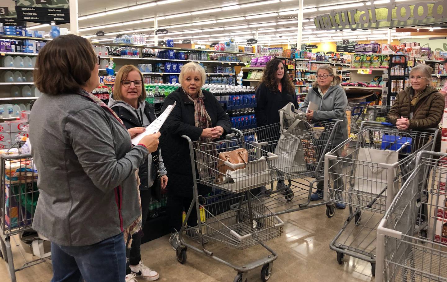 Anne Lauterjung goes over a handout of nutritional information with shoppers during the OSF grocery store tour at Kroger in Ottawa on Sunday, Nov. 13, 2022.