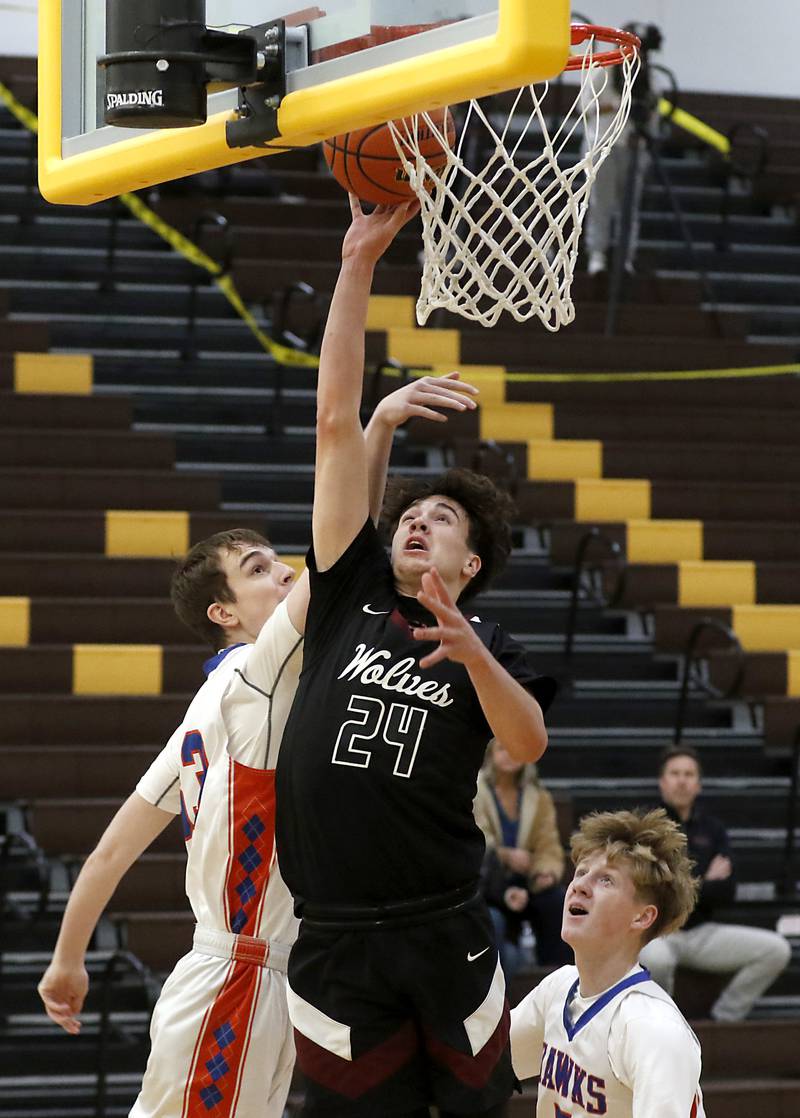 Prairie Ridge's Ben Gablenz is fouled by Hoffman Estates’ Abell Bosnjak as he drives to the basket between Bosnjak and Connor Kurzynski during a Hinkle Holiday Classic basketball game Wednesday, Dec. 28, 2022, at Jacobs High School in Algonquin.