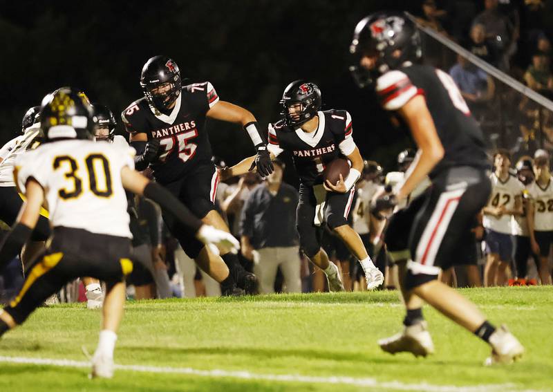 Erie-Prophetstown's Caleb Reymer leads the way for quarterback Keegan Winckler to head up field Friday, Oct. 3, 2025 as the Panthers hosted the Riverdale Rams in Erie for the Panthers homecoming game.