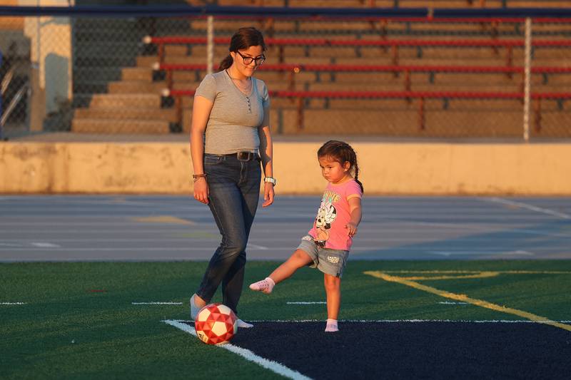 Citlali, left, and her little sister play soccer before the start of the fireworks at Joliet Memorial Stadium in on Thursday July 4, 2024.