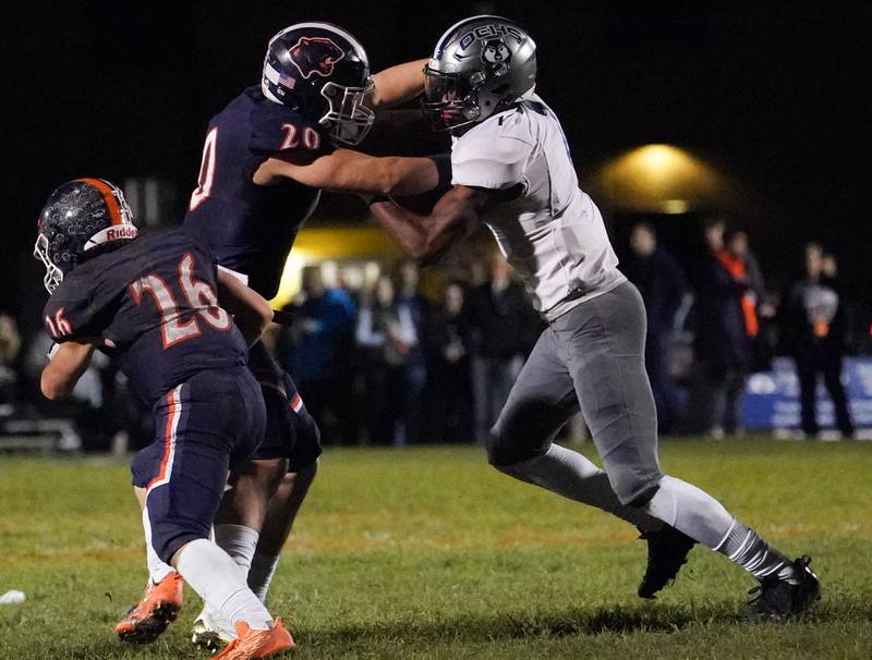 Oswego’s Dylan King (20) blocks Oswego East's Andrew Wiggins (1) during a football game at Oswego High School on Friday, Oct. 20, 2023.