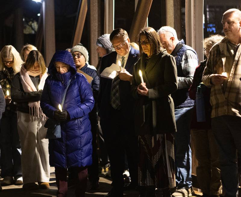 Locals gather with area faith leaders for a candlelight vigil at the Peace on Earth Bridge as part of an International Peace Vigil on Sunday, Nov.23, 2025, in Batavia.