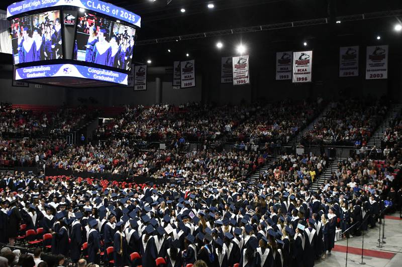 Oswego East graduates whatch the video board to watch classmates during the processional of the graduation ceremony held on Saturday May 17, 2025, held at the Convocation Center in DeKalb.