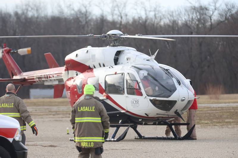 La Salle firefighters set up a landing zone for OSF Lifeflight helicopter while landing to assist during a three vehicle crash near the entrance to La Sale Speedway on Monday, Jan. 12, 2026 on U.S. Route 6 in La Salle. The crash happened around 8:30a.m. Crews from Utica and La Salle responded to the scene. OSF Lifeflight helicopter landed in the parking lot of La Salle Speedway to transport one patent.
