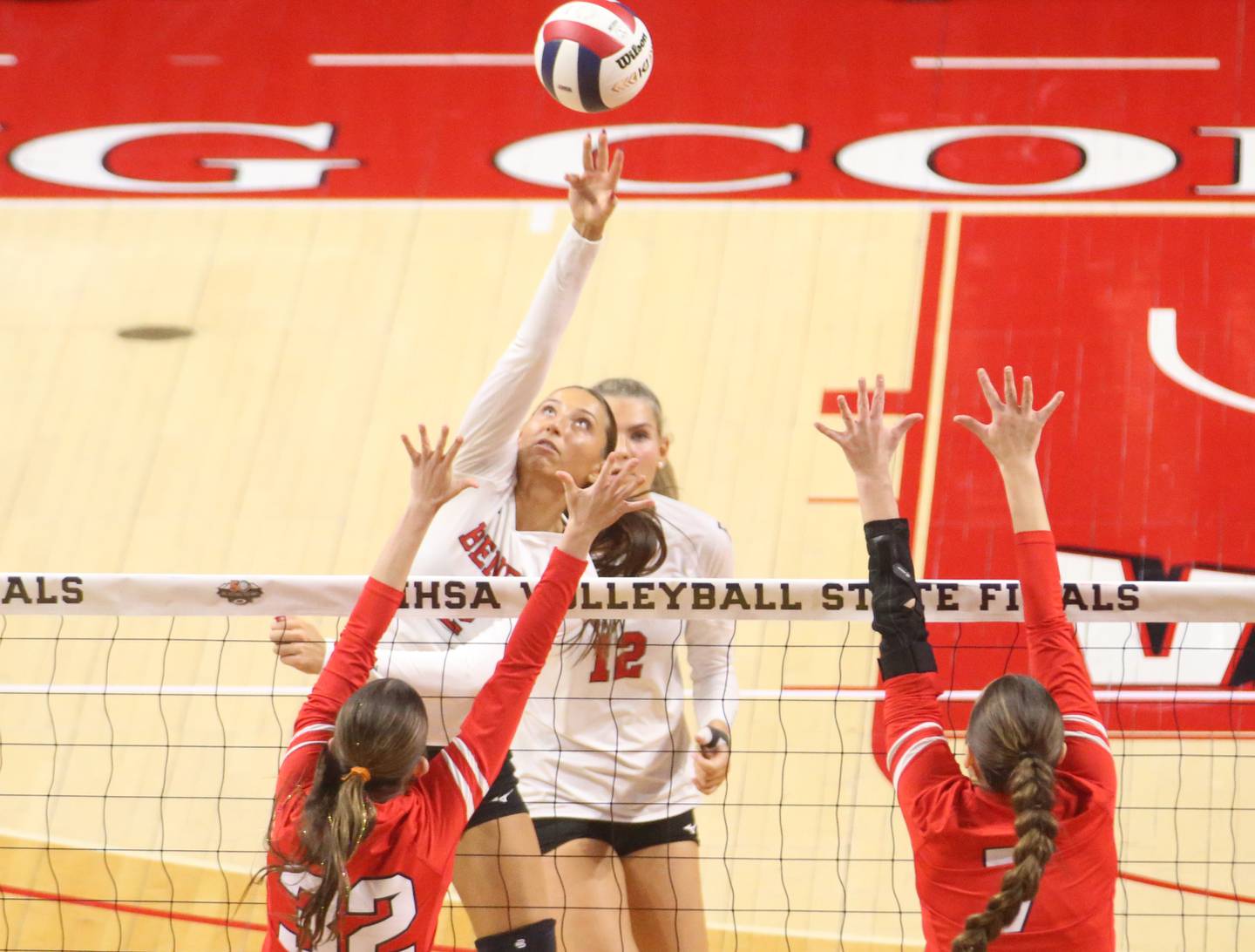 Benet's Gabby Stasys tips the ball past Huntley's Izzy Whitehouse and teammate Jocelyn Erling during the Class 4A State semifinal game on Friday, Nov. 15, 2024 at CEFCU Arena in Normal.