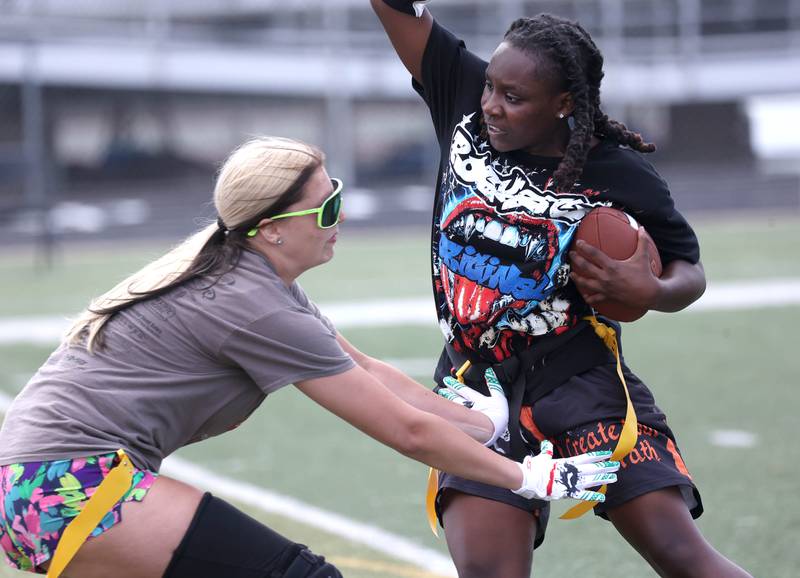 DeKalb’s Kaylee Tenard tries to avoid a defender after making an interception Wednesday, Aug. 20, 2025, during the first practice of the DeKalb High School flag football team. The squad is preparing for their inaugural season.