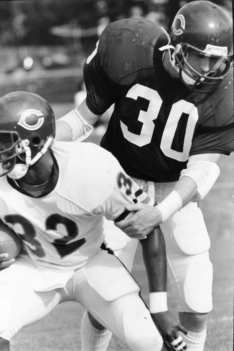 Chicago Bears running back Anthony Hutchinson breaks free of cornerback John Hill during training camp on Wednesday, June 12, 1985 in Platteville Wis.
