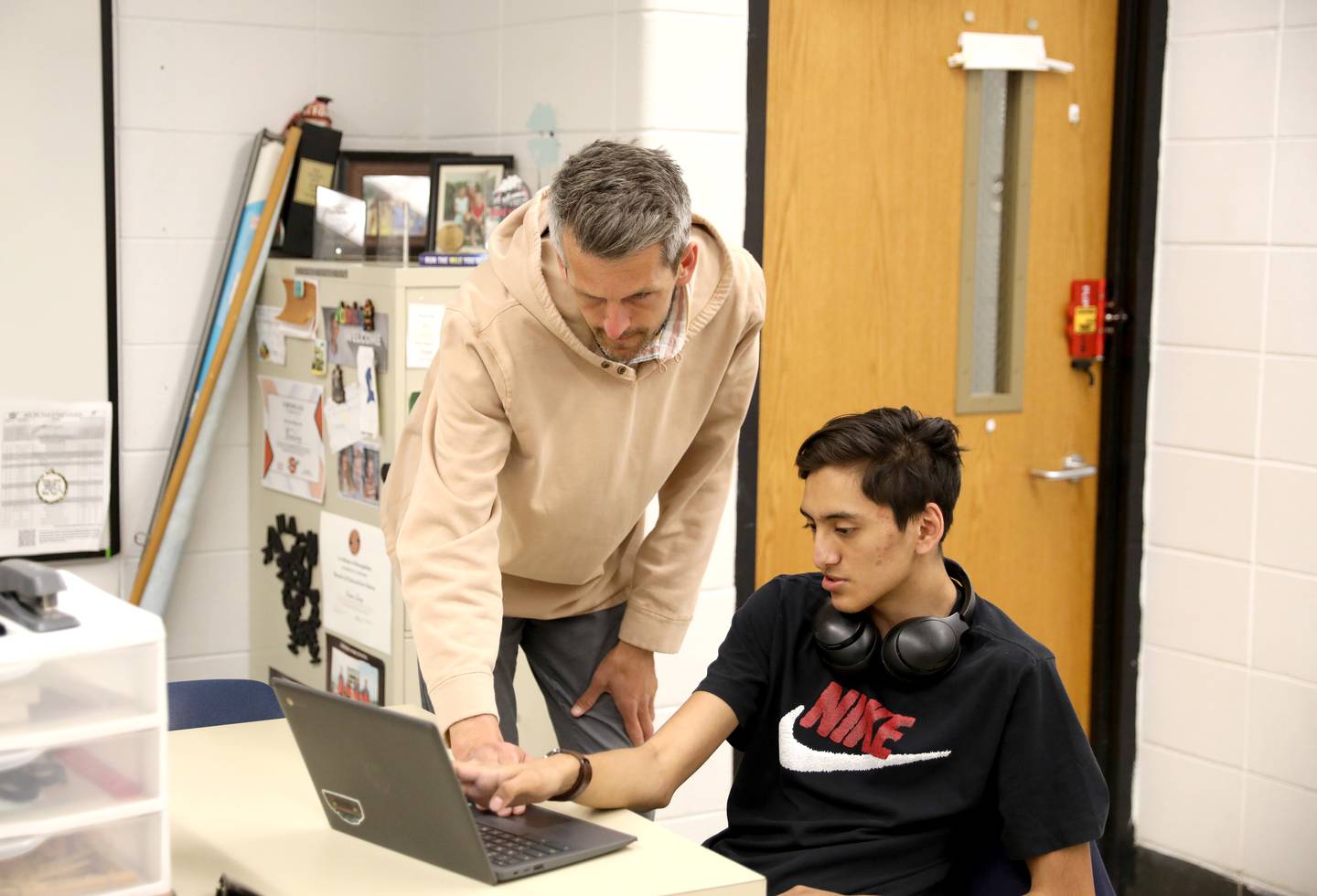 Sandwich High School multilingual teacher Brian Long works with student Brian Garcia. Long also coaches track and cross country at the school.