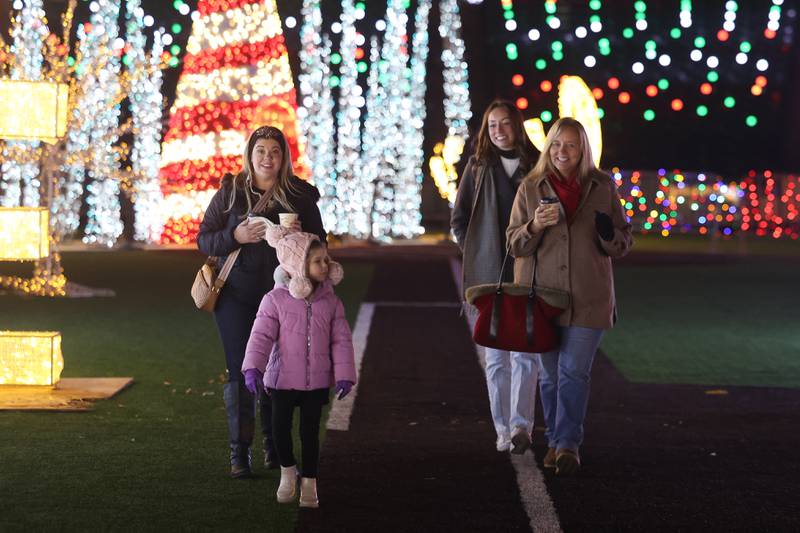 A family enjoys hot chocolate and lights at the GLOW Holiday Festival at Slammers Stadium on Wednesday, Nov. 27, 2024 in Joliet.