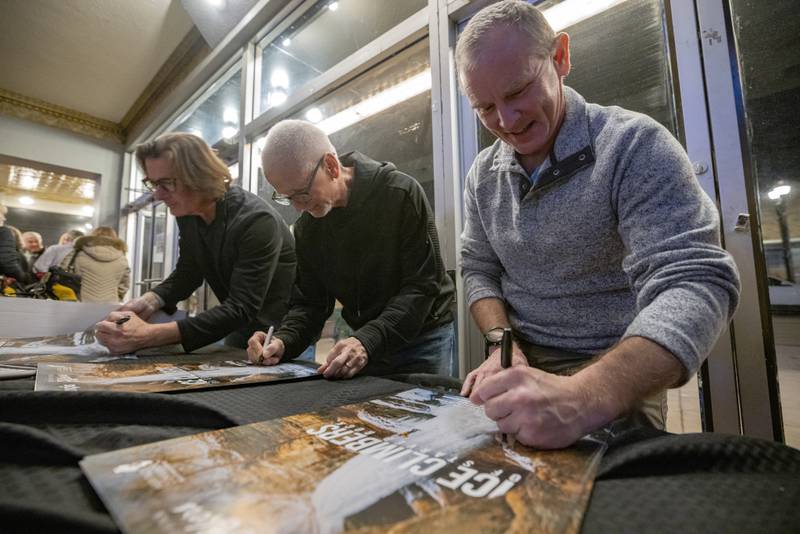 The stars of Ice Climbers of Starved Rock Wes Black (right), Dave Everson (middle), and Bruce Turner (left) autograph movie posters at the end of the first showing at Roxy Theater on February 3, 2024.