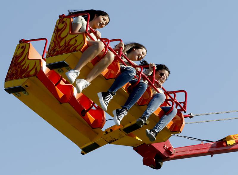 Girls ride on the Downdraft ride during the first day of the McHenry County Fair Tuesday, August 2, 2022, at the fairgrounds in Woodstock. The fair funs through Sunday, Aug. 7.  Entry to the fair is $10 for anyone over age 14, and $5 for chidden ages 6 to 13. Ages 5 and under are free.