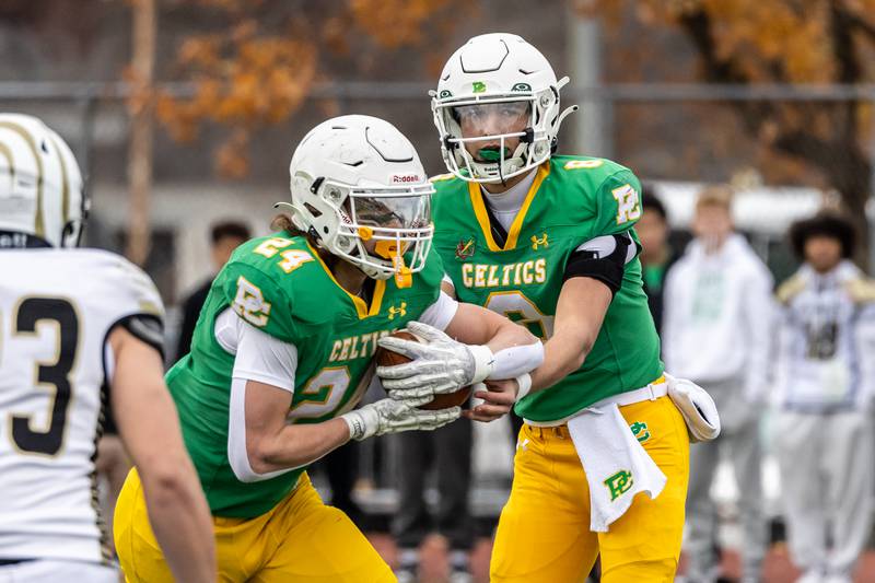 Providence's Dominic Vita hands-off to Broden Mackert during a 5A varsity football semifinal game against Oak Forest at Providence Catholic High School on Nov. 22, 2025.