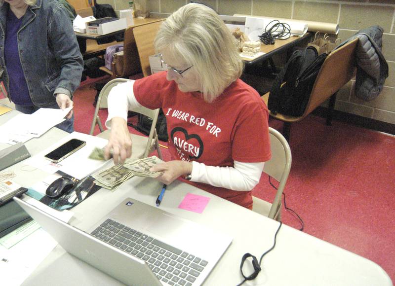 Dixon Schools Foundation Treasurer Joan Roth counts 50/50 raffle money at the Stupor Bowl at Reagan Middle School in Dixon.