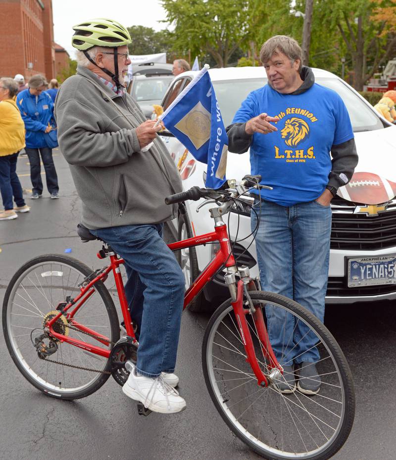 Lyons Township High School class of ’72 alumni, Phil Myers (left) of La Grange and Bill Wilson of La Grange Highlands chat in the north campus parking lot before the annual homecoming parade on Saturday, Sept. 24, 2022.