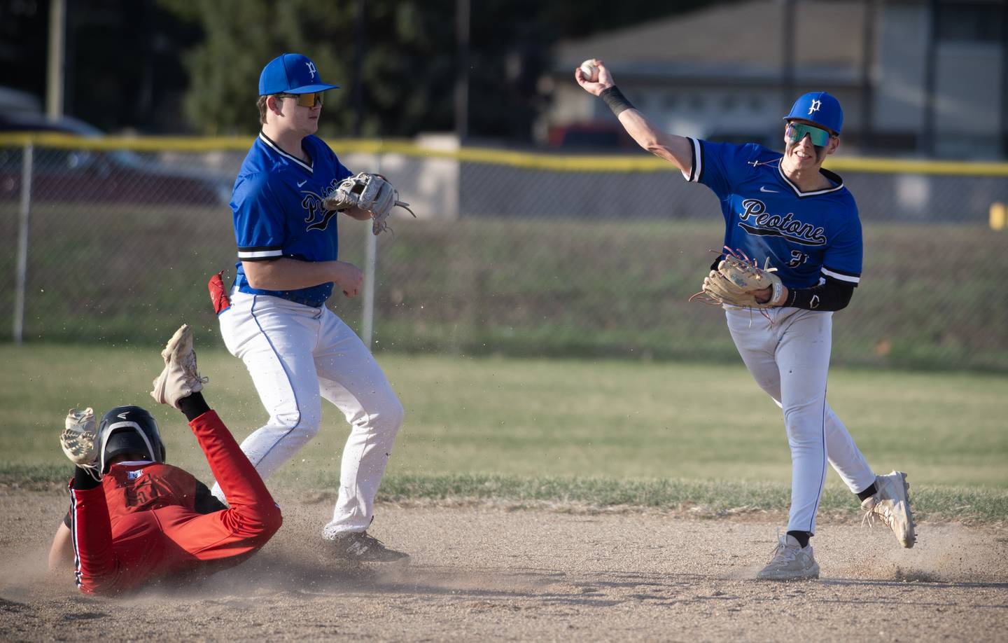 Peotone's Tyler Leitelt, right, fields a ground ball and throws onto first base in the third inning of the game against Momence on March 28, 2025.