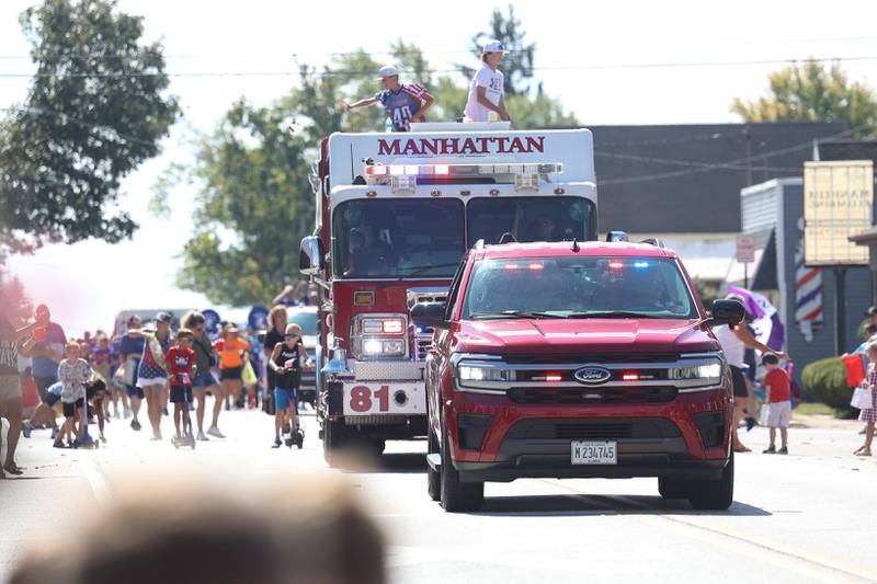 Kids throw candy to the crowds atop of a Manhattan Fire Department engine in the Labor Day Parade on Monday, Sept. 4, 2023 in Manhattan.
