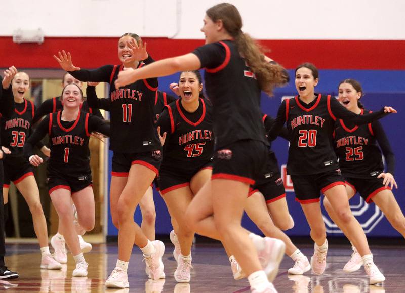 Huntley’s Red Raiders rejoice as Luca Garlin drains a half-court shot to conclude the first quarter against Maine South in Komaromy Holiday Classic varsity girls basketball championship game action on Monday, Dec. 30, 2024, at Dundee-Crown High School in Carpentersville.