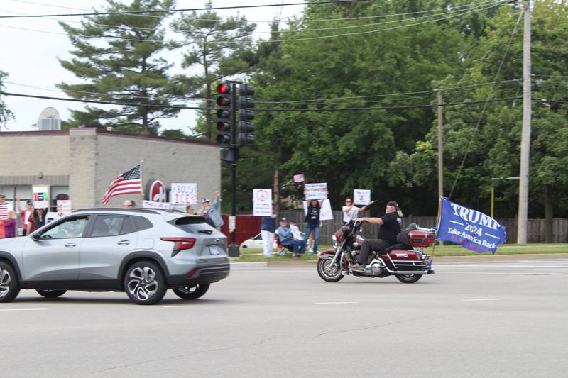 A motorcycle rider drives past the "No Kings" protest with a Trump flag on June 14, 2025 in McHenry.