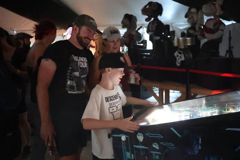 Tommy and Sam Enright watch their son Eamon play pinball at Riot Fest on Saturday, Sept. 21, 2024 in Chicago.