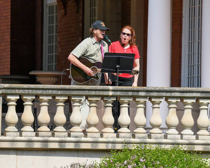 Terri Crain Goodman along with Ron Lofton sing and play the guitar as spectators listen during the Memorial Day ceremony held on the Ellwood house lawn in DeKalb on Monday May 30th.