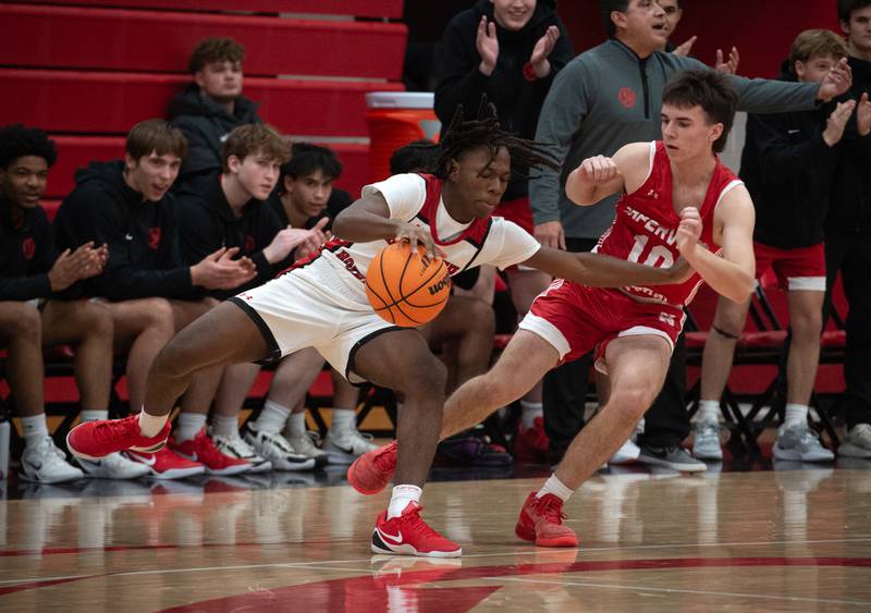 Bradley-Bourbonnais's Kobe Lawrence, left, controls the ball as Naperville Central's Cooper Page, right, guards in a game on Monday, December 15, 2025.