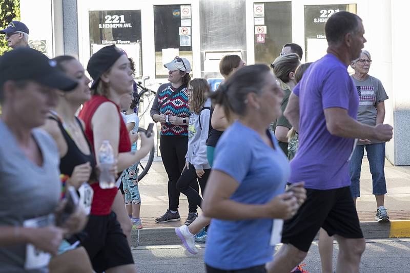 Spectators watch and cheer as a group of runners pass the Dixon library during the Reagan Run Saturday, July 6, 2024.