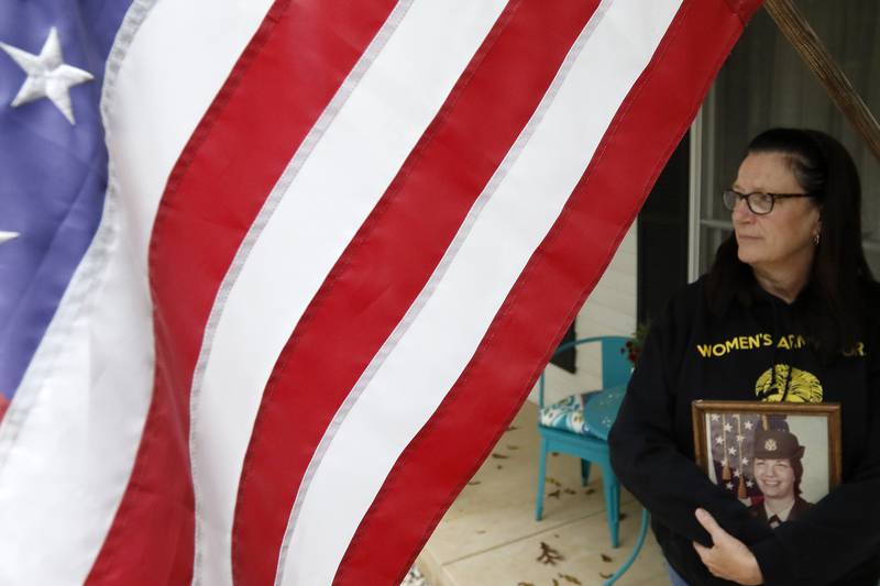 U.S. Army veteran Sgt. E-5 Lolly Peters poses for a portrait Thursday, Oct. 21, 2021, at her home in McHenry. Peters, who served from 1976 to 1983, attended an all-woman honor flight from Chicago on Oct. 6.  Peters, 63, was the youngest on her flight and the oldest veteran was 104.