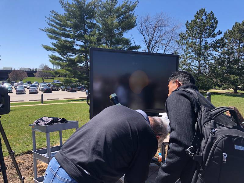 Paul Hamill's astronomy students at McHenry County College watch the eclipse through a telescope that is also broadcasting the image on TV on April 8, 2024.